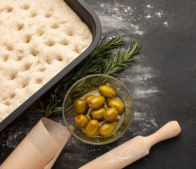 Photo gratuite vue de dessus de la pâte de focaccia et des olives