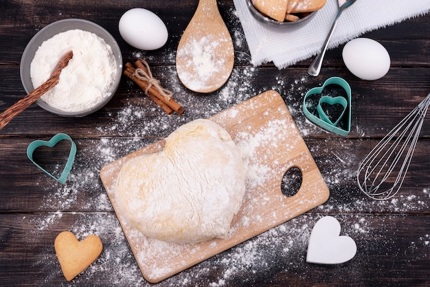 Photo gratuite vue de dessus de la pâte en forme de coeur avec des ustensiles de cuisine