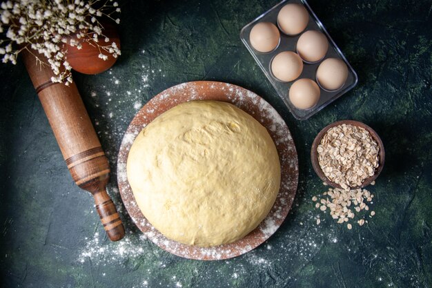 Vue de dessus de la pâte fraîche crue sur fond bleu foncé Pâtisserie Cuire le gâteau Pâte au four crue Tarte au hotcake fraîche