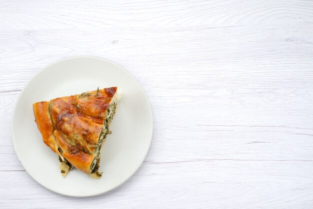 Vue de dessus de la pâte de légumes verts cuits en tranches à l'intérieur de la plaque blanche sur le fond blanc repas pâtisserie déjeuner verts