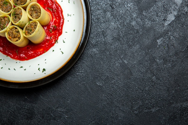 Vue de dessus de la pâte avec des tranches de pâte de viande en tranches avec sauce tomate sur espace gris