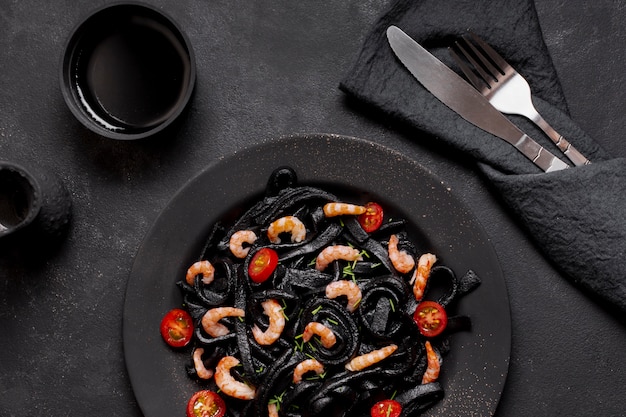 Vue de dessus des pâtes aux crevettes noires avec sauce soja et couverts