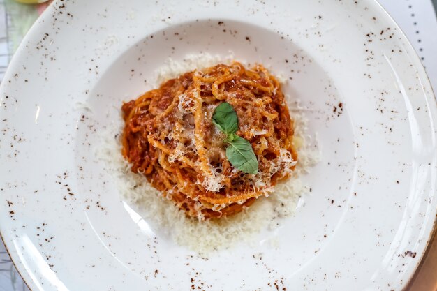 Vue de dessus pâtes à la bolognaise avec du fromage râpé dans une assiette