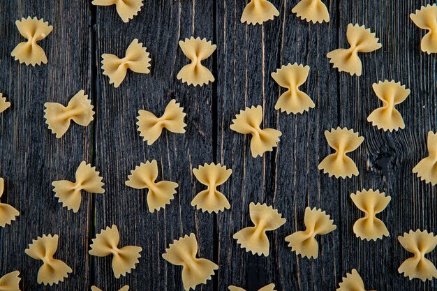 Vue de dessus des pâtes farfalle sur fond de bois noir