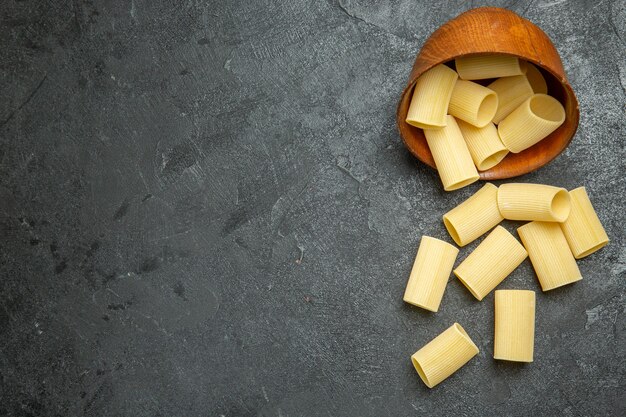 Vue de dessus des pâtes italiennes crues peu formées sur fond gris pâte de pâtes alimentaires repas crus