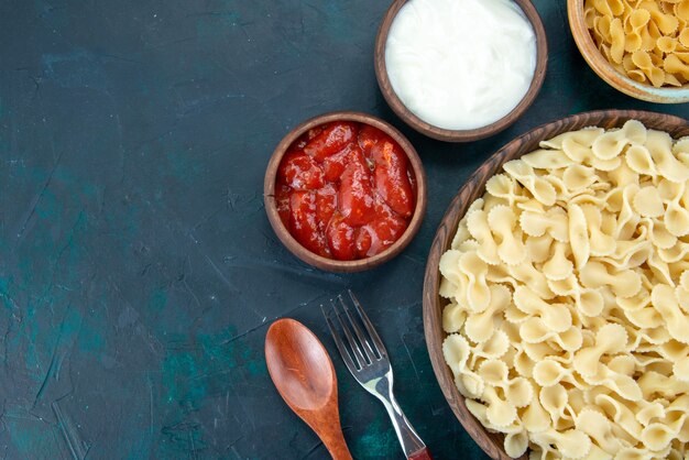 Vue de dessus des pâtes italiennes cuites avec assaisonnements sur dark