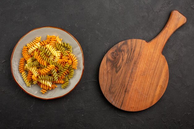 Vue de dessus des pâtes italiennes cuites pâtes en spirale inhabituelles à l'intérieur de la plaque sur l'espace sombre