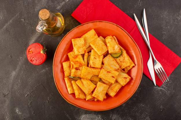 Une vue de dessus des pâtes italiennes cuites avec sauce tomate et concombre à l'intérieur de la plaque