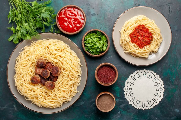 Vue de dessus des pâtes italiennes cuites avec de la viande et des assaisonnements sur la surface bleu foncé