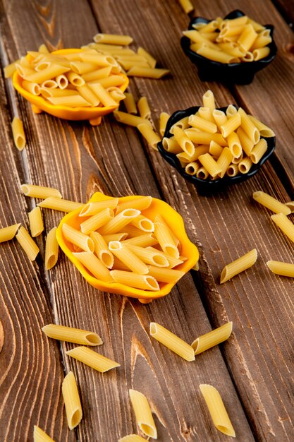 Photo gratuite vue de dessus des pâtes penne sur fond de bois