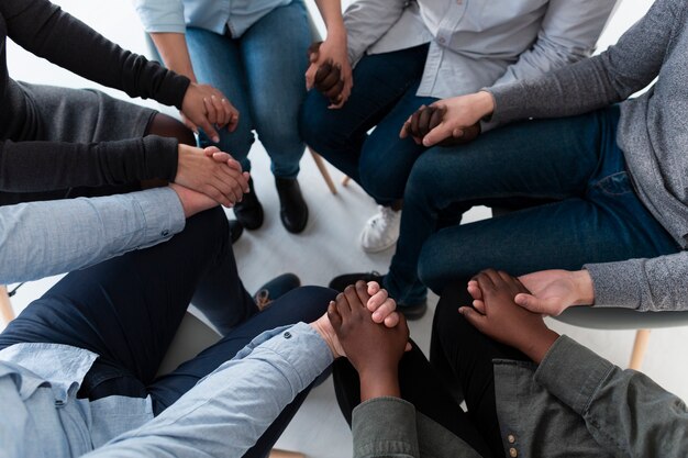 Vue de dessus des patients debout en cercle et main dans la main