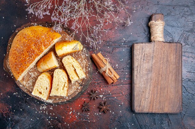 Vue de dessus de la pâtisserie sucrée coupée en morceaux sur une surface sombre