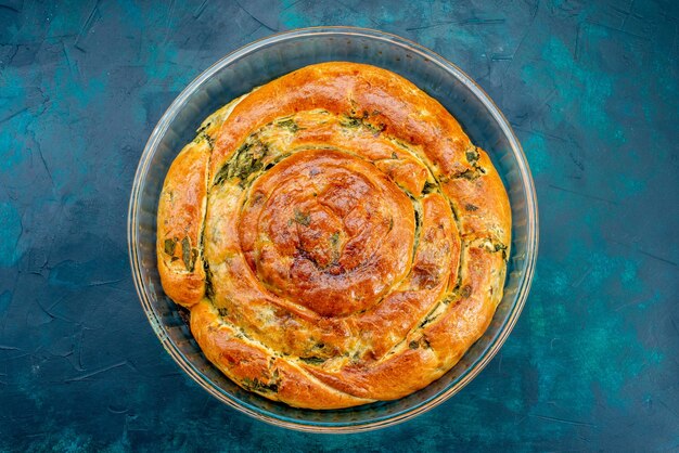 Vue de dessus pâtisserie verdoyante avec des verts à l'intérieur sur le fond sombre.