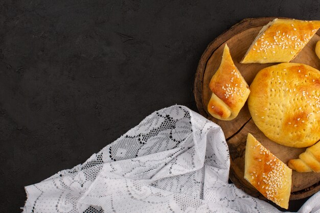 Vue de dessus des pâtisseries et des croissants sur le bureau en bois marron et fond sombre