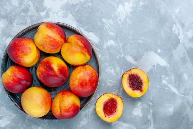 Photo gratuite vue de dessus pêches mûres fraîches délicieux fruits d'été sur un bureau blanc clair