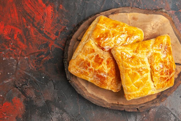 Vue de dessus de penovani khachapuri sur planche de bois sur une surface rouge foncé