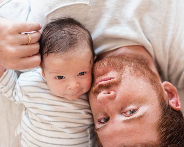 Vue de dessus père et bébé posant ensemble