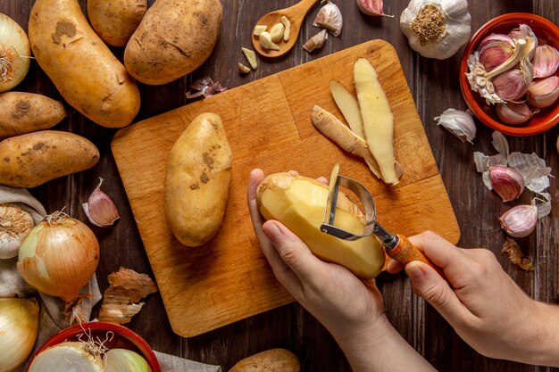 Vue de dessus de la personne qui épluche les pommes de terre