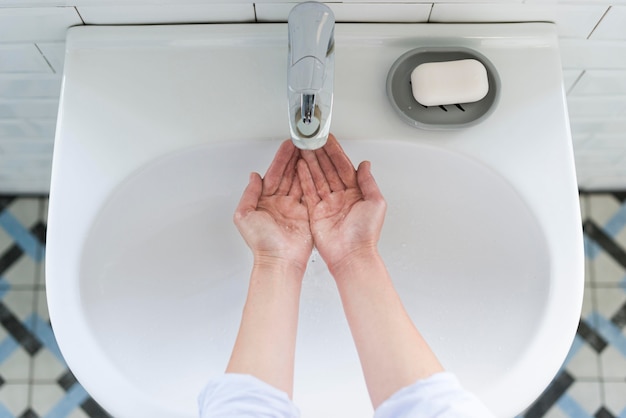 Vue de dessus d'une personne se lavant les mains à l'évier