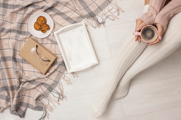 Vue de dessus de la personne tenant la tasse de café avec des biscuits et un plateau