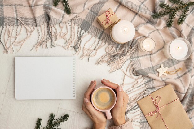 Vue de dessus de la personne tenant la tasse avec couverture et bougies