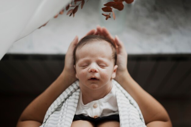 Vue de dessus petit bébé dort dans les mains de la mère