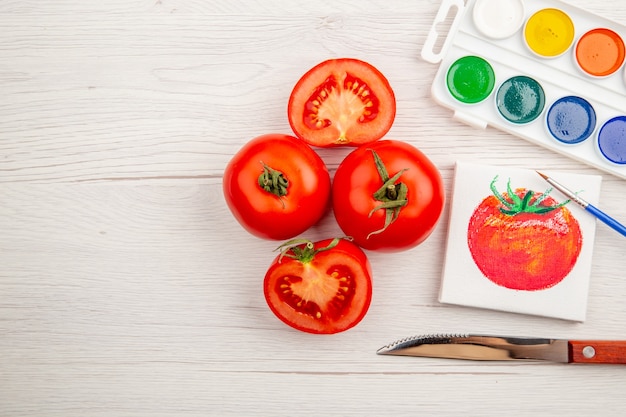 Photo gratuite vue de dessus petit dessin de tomate avec des tomates fraîches sur un bureau blanc