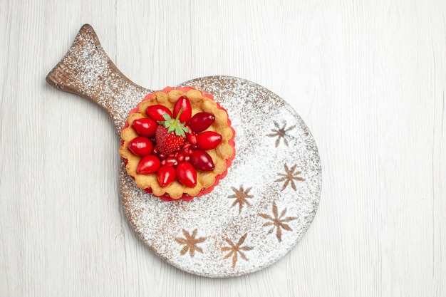 Vue de dessus petit gâteau aux fruits frais sur un bureau blanc