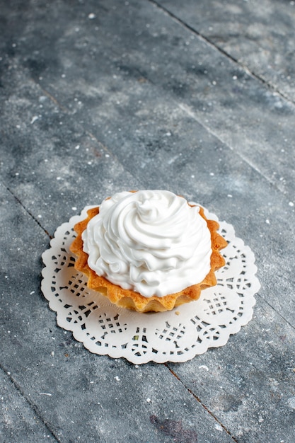 Vue de dessus petit gâteau crémeux cuit délicieux isolé sur le gris clair bureau gâteau biscuit couleur douce sucre crème