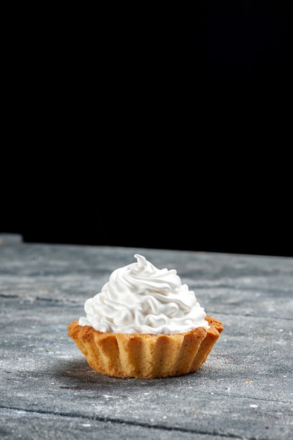 Vue de dessus petit gâteau crémeux cuit délicieux isolé sur la table grise gâteau biscuit crème photo douce