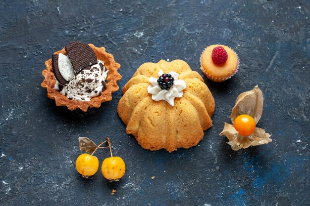 Vue de dessus petit gâteau délicieux avec cookie sur le bureau sombre biscuit gâteau aux fruits sucrés