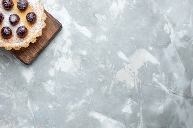 Vue de dessus petit gâteau délicieux avec du sucre de fruits en poudre sur le gâteau de bureau léger gâteau biscuit sucre sucré