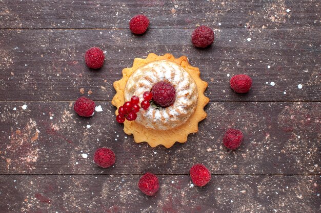 Vue de dessus petit gâteau simple avec du sucre en poudre aux framboises et canneberges sur la table en bois brun berry fruit cake sweet bake