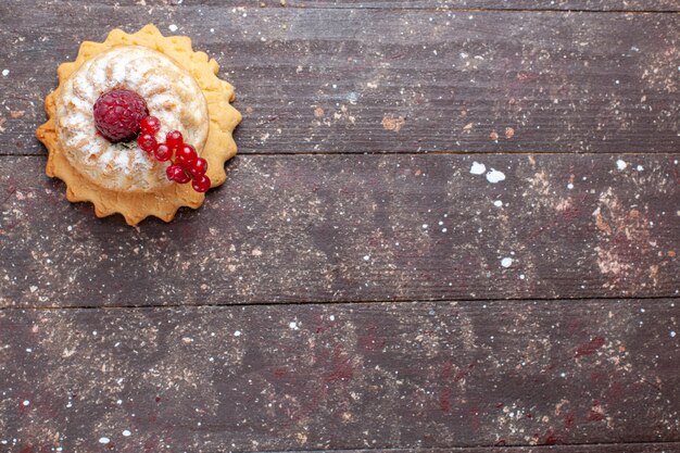 Photo gratuite vue de dessus petit gâteau simple avec du sucre en poudre framboise et canneberges sur le fond rustique en bois berry fruit cake sweet bake