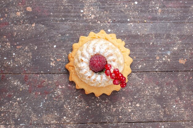 Vue de dessus petit gâteau simple avec du sucre en poudre framboise et canneberges sur le fond rustique en bois berry fruit cake sweet