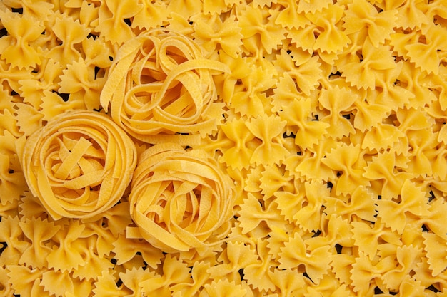 Vue de dessus petite pâte de pâtes crues repas repas couleur photo pâtes italiennes beaucoup