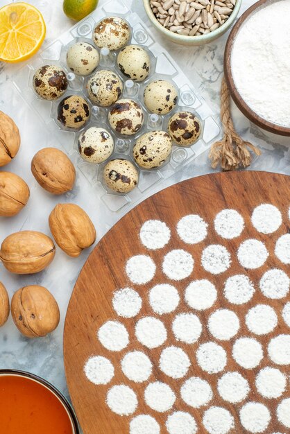 Vue de dessus petite pâte ronde autour d'oeufs gelée farine et pain noir sur fond blanc cuire au four tarte couleur oeuf lait petit déjeuner hotcake