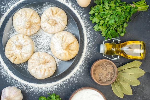 Vue de dessus petites boulettes crues avec différents ingrédients sur fond gris nourriture tarte gâteau cuire savoureuse viande pâte couleurs farine cuire au four