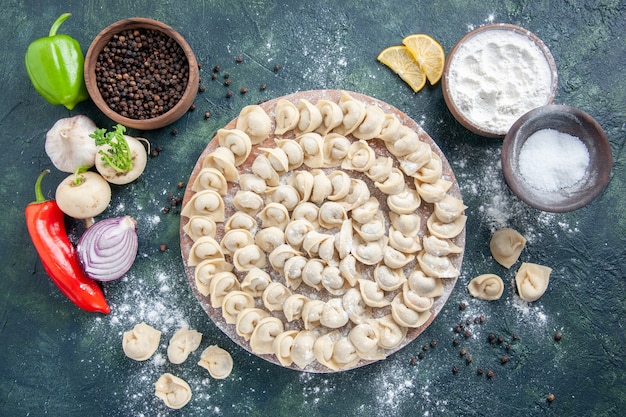 Vue de dessus petites boulettes crues avec de la farine sur fond gris foncé couleur de la pâte nourriture plat alimentaire viande repas calorique