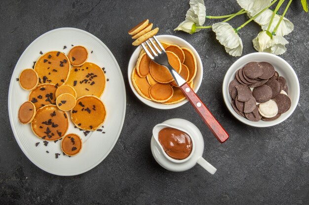 Vue de dessus de petites crêpes avec des cookies sur gris