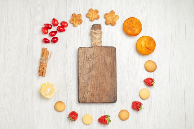 Vue de dessus petits biscuits aux fruits sur un bureau blanc