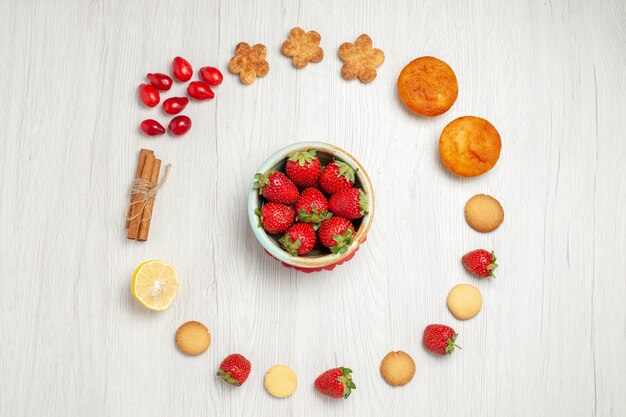 Vue de dessus petits biscuits aux fruits frais sur un bureau blanc