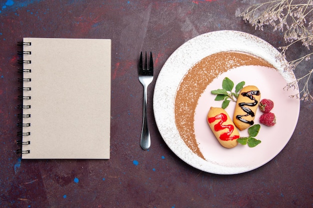 Vue de dessus de petits biscuits sucrés à l'intérieur d'une assiette conçue sur fond noir