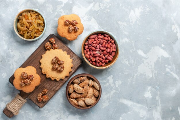 Vue de dessus de petits gâteaux aux pistaches et noix sur une surface blanche claire