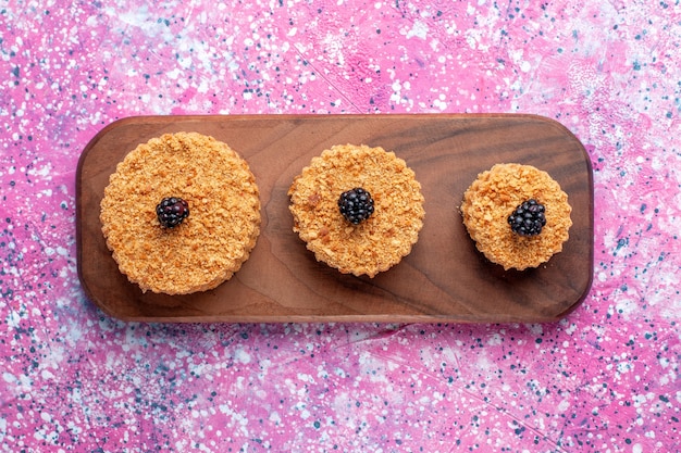 Vue de dessus de petits gâteaux délicieux ronds formés sur la surface rose