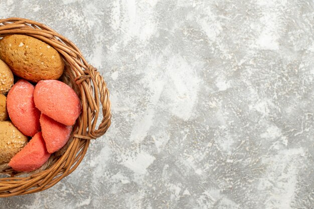 Vue de dessus de petits gâteaux sucrés à l'intérieur du panier sur fond blanc clair