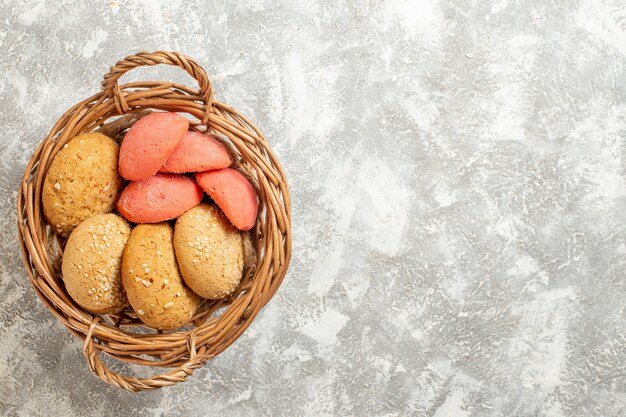 Vue de dessus de petits gâteaux sucrés à l'intérieur du panier sur fond blanc