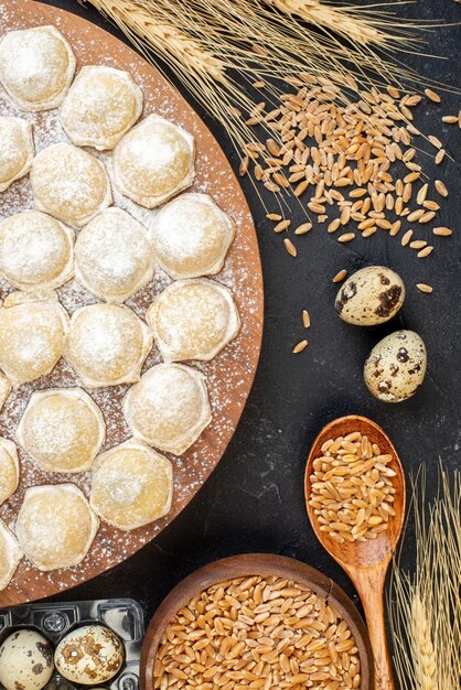 Vue de dessus petits morceaux de pâte avec de la farine sur fond sombre pâte à tarte boulettes de pâte à tarte viande de pain