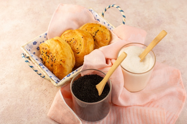 Une vue de dessus des petits pains chauds savoureux frais à l'intérieur du bac à pain avec du sel et du poivre sur rose