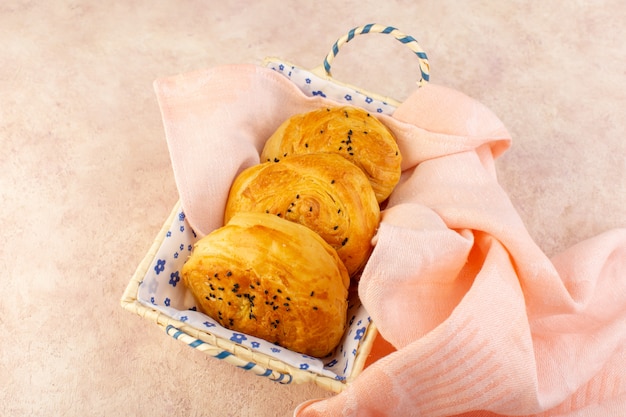 Une vue de dessus des petits pains chauds savoureux frais à l'intérieur du bac à pain sur rose